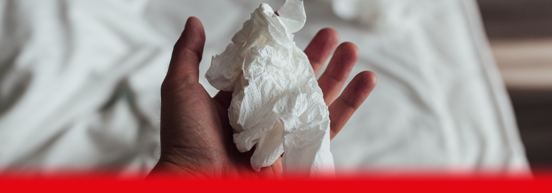 man holding used tissue