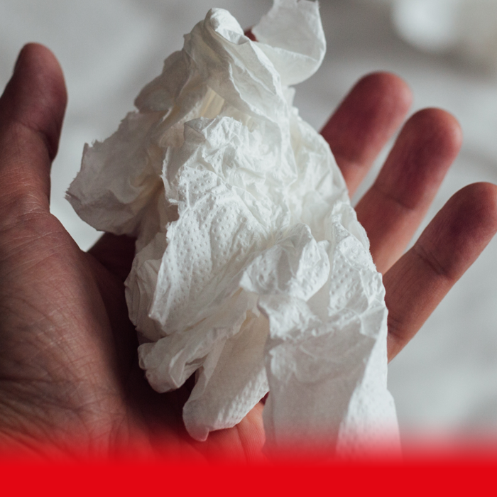man holding used tissue