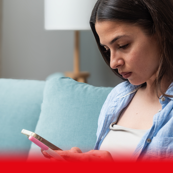 woman on phone and holding hcg test