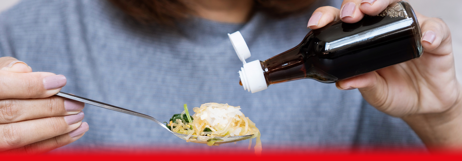 woman pouring sauce on food
