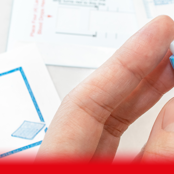 patient taking finger prick test at home